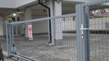 A gated parking area with a no-parking sign.