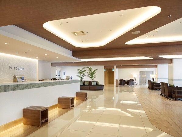 A modern hotel lobby with a reception desk, seating area, and a large potted plant. - Shinagawa Prince Hotel N Tower (Tokyo)