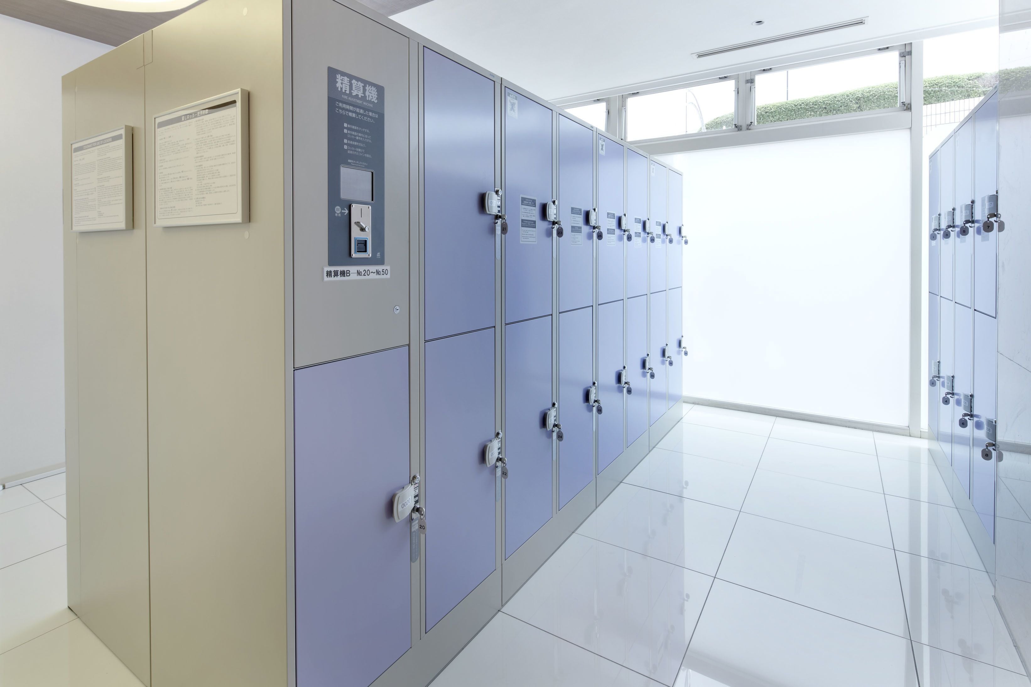 A row of lockers with a control panel and informational signs.