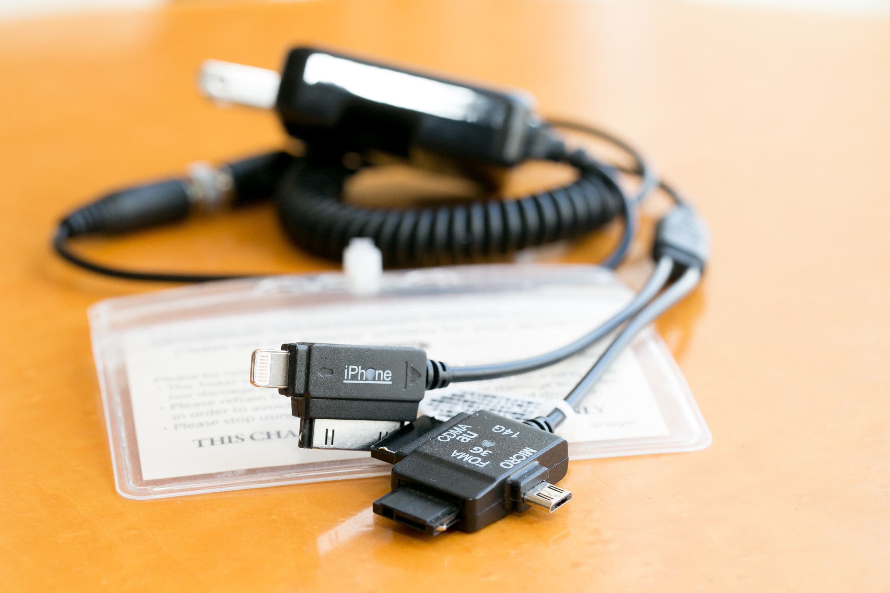 A charging cable and adapter for an iPhone on a table.