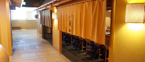 Un pasillo con esteras de tatami, muebles de madera y decoración japonesa tradicional.