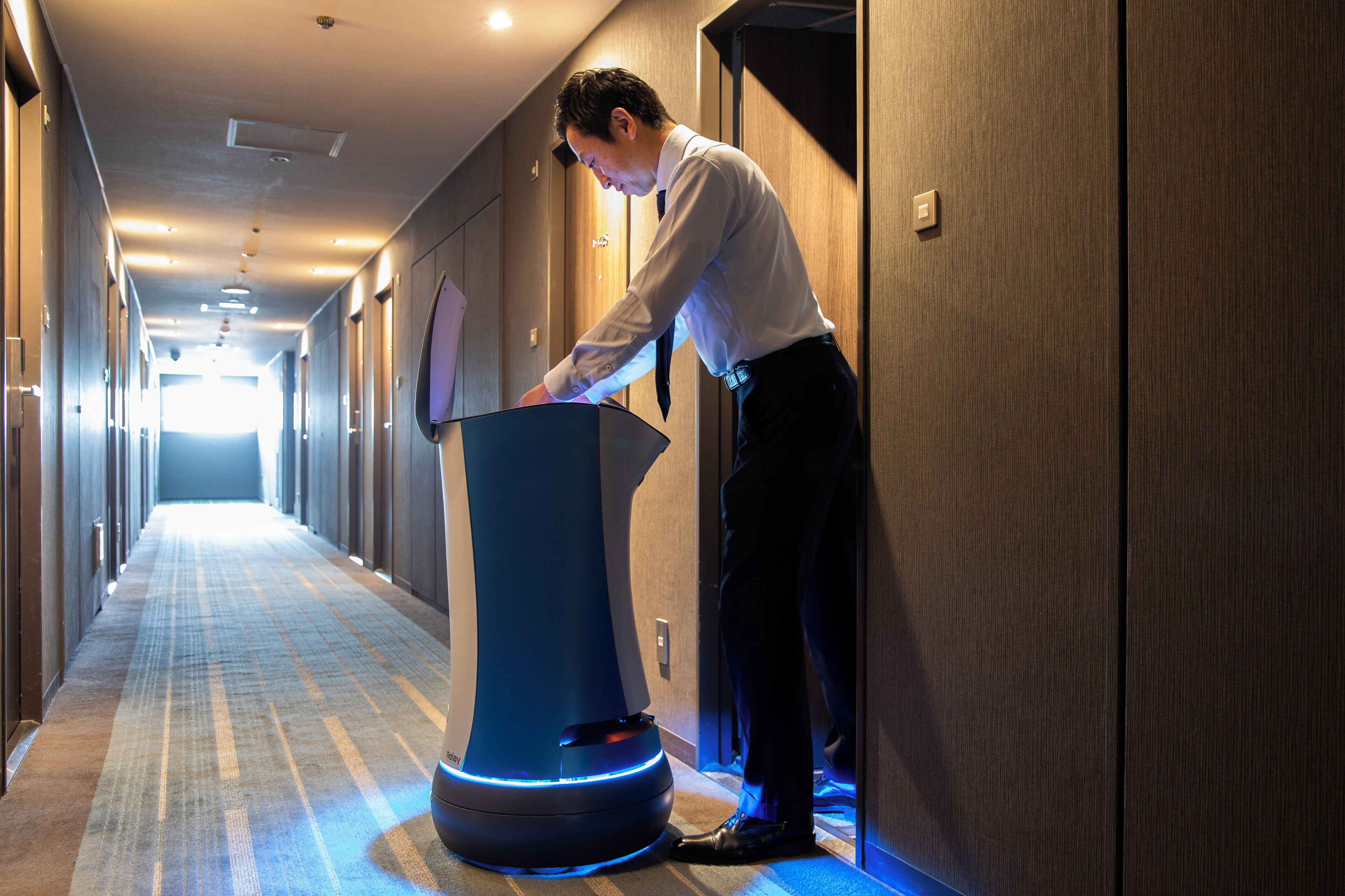 A hotel corridor with a modern podium and wooden walls.