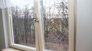 A window with a view of leafless trees and a fence. - 270 Pulawska (Warsaw)