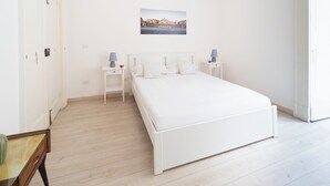 A minimalist bedroom with a single bed, bedside tables, and a wall-mounted picture. - Monteoliveto Modern Flat by Wonderful Italy (Naples)