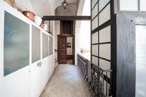 A narrow corridor with tiled flooring, a metal railing, and a door with a window. - Monteoliveto Modern Flat by Wonderful Italy (Naples)