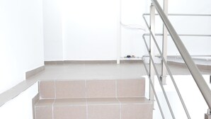 A staircase with beige tiles and a metal handrail. - Alexys Residence 8 (Iasi)