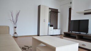 A modern living room with a sofa, a coffee table, a TV stand, and a wardrobe. - Alexys Residence 8 (Iasi)