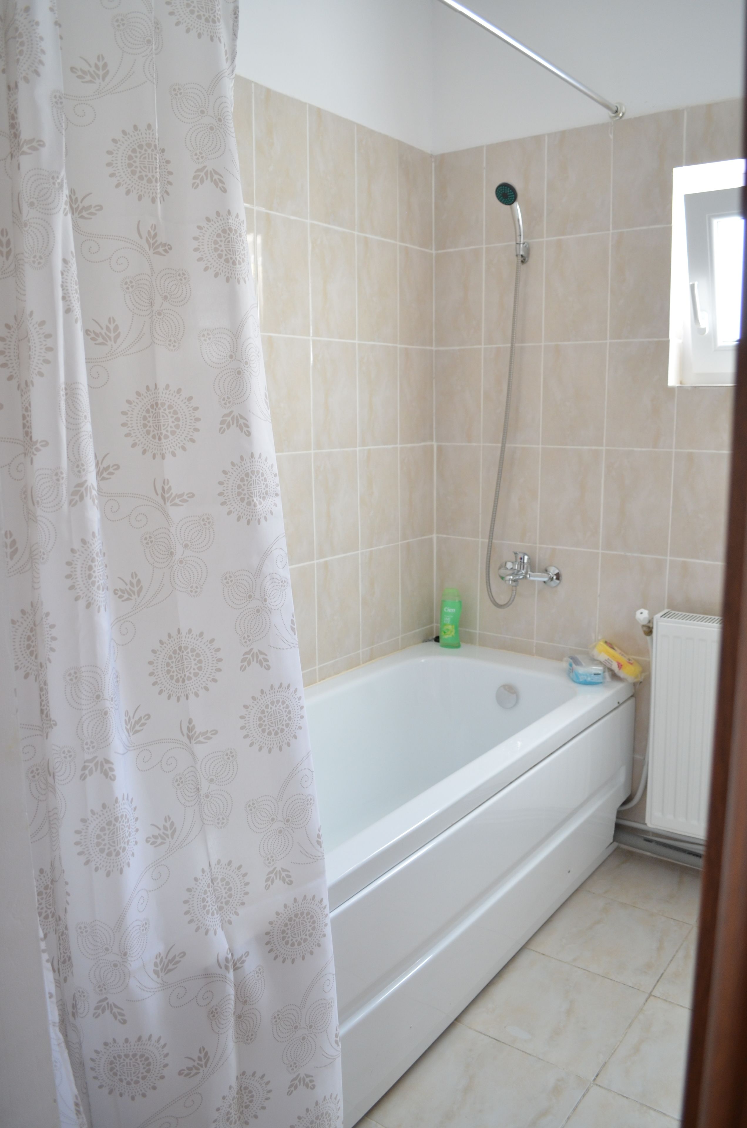 A bathroom with a bathtub, shower, and toilet.