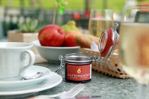 A table setting with a white cup, saucer, a bowl of fruit, a jar of jam, and a glass of wine. - Gafringwirt (Euratsfeld)