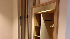 Un vestidor con paneles de madera, una puerta de espejo y estantes empotrados.