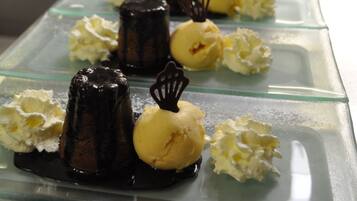A dessert tray with various ice cream flavors and chocolate-covered items on a glass table.