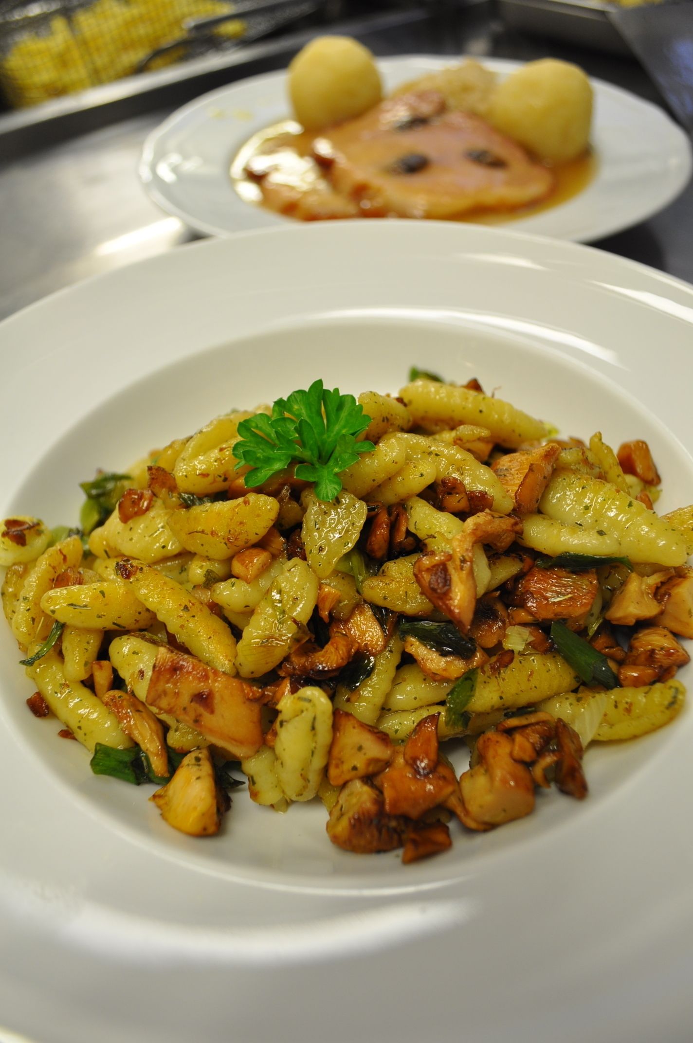 Une assiette de pâtes aux champignons et aux herbes, garnie de persil.