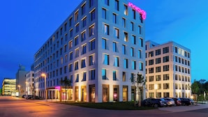 A multi-story hotel with a modern design, featuring a prominent neon sign on the top. - Moxy Darmstadt (Darmstadt)