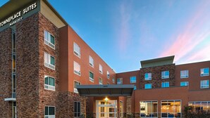 A multi-story hotel with a brick facade, a central entrance with a glass door, and a sign indicating it is a Marriott hotel.