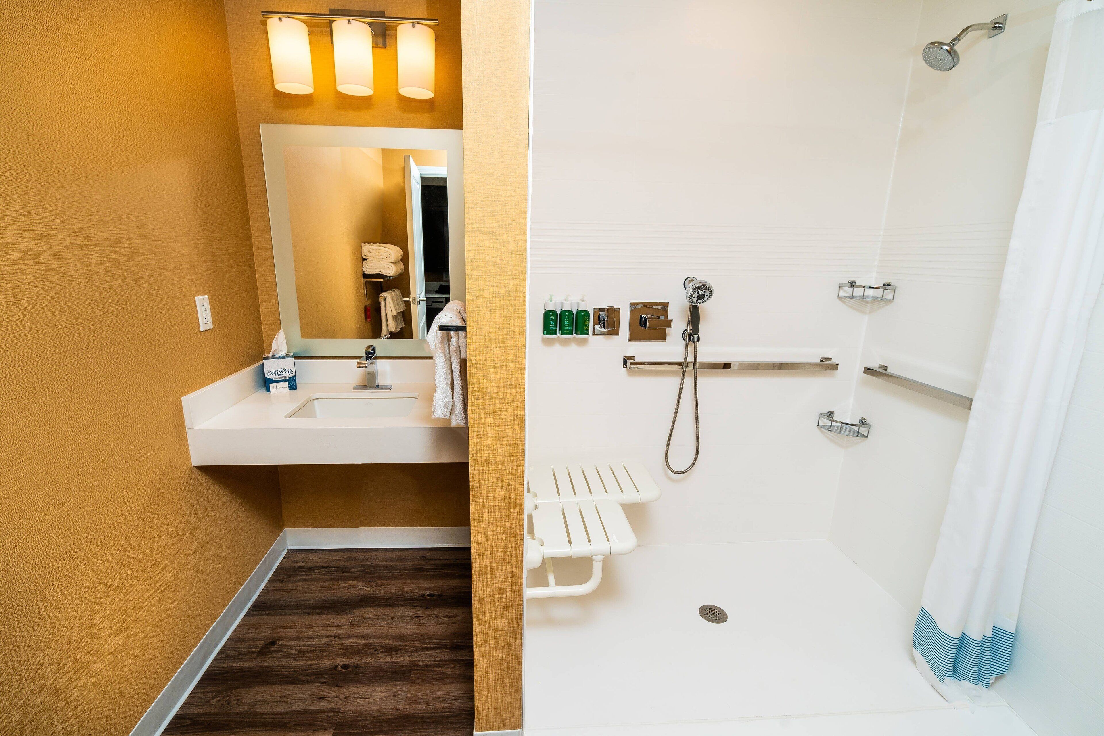 Ein Badezimmer mit Waschbecken, Spiegel und Dusche.