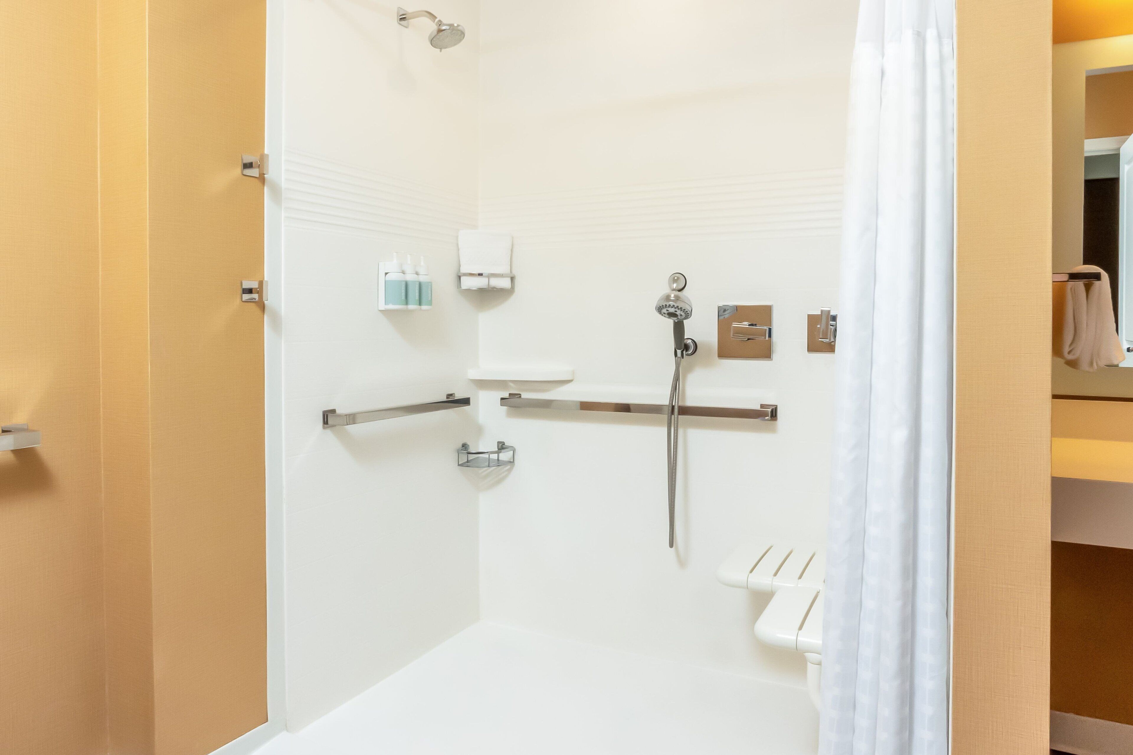 A modern bathroom with a shower, toilet, and sink.