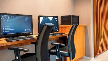 Un espacio de oficina moderno con dos escritorios, cada uno con una computadora y teclado.
