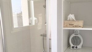 A modern bathroom with a glass-enclosed shower, a washing machine, and a shelf with a tissue box. - Estrella (Les Sables-d'Olonne)