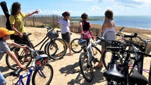 A group of people with bicycles on a sandy beach, overlooking the ocean. - Estrella (Les Sables-d'Olonne)