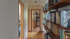 Un couloir étroit, doté d’un plancher en bois et de bibliothèques de part et d’autre.