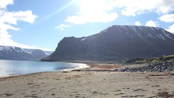 En strand med et bjerg i baggrunden.