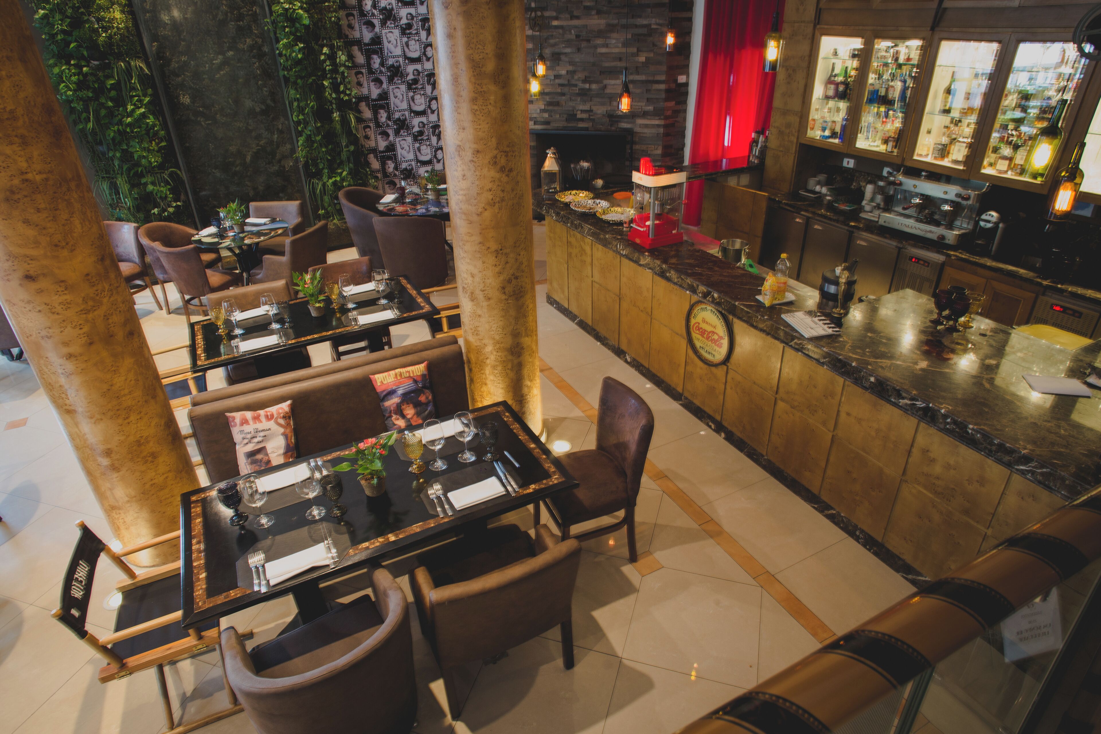 A restaurant with multiple tables and chairs, a bar area, and a fireplace.
