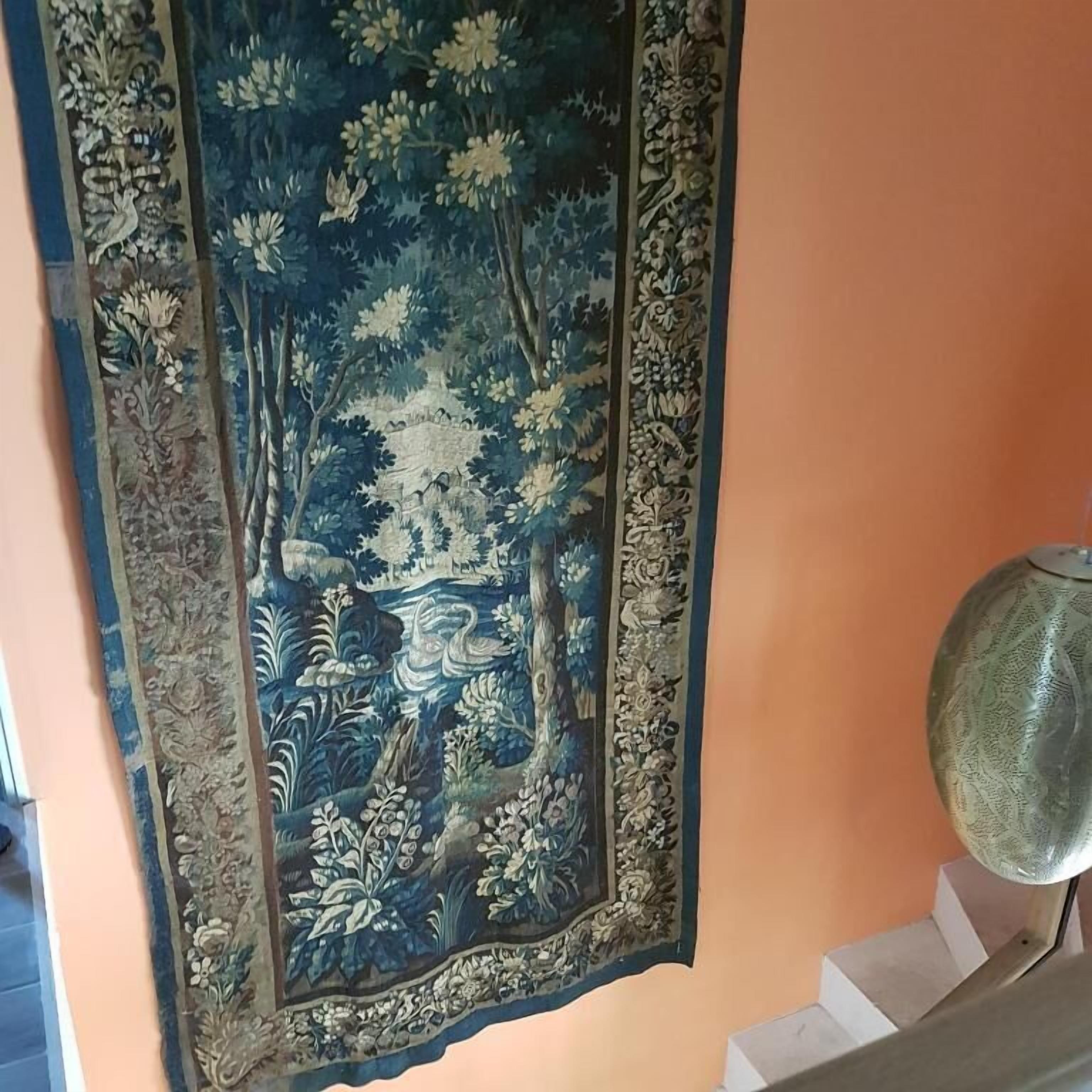 Um tapeçário com cena de floresta pendurado na parede.