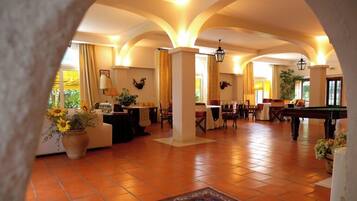 Un'ampia zona relax con tavolo da biliardo, comodi posti a sedere e un'atmosfera accogliente e invitante.