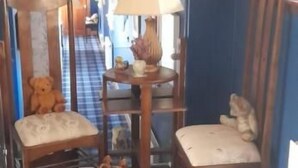 A room with a blue wall, a wooden chair, a small rug, and a lamp. - Riverside House (Callander)