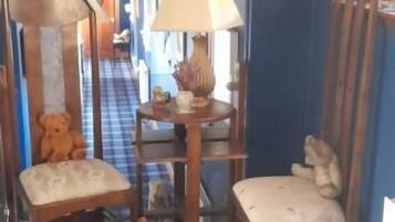 A room with a blue wall, a wooden chair, a small rug, and a lamp.