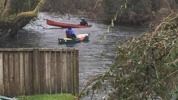 Un río con dos canoas, una roja y otra verde, con gente remando.