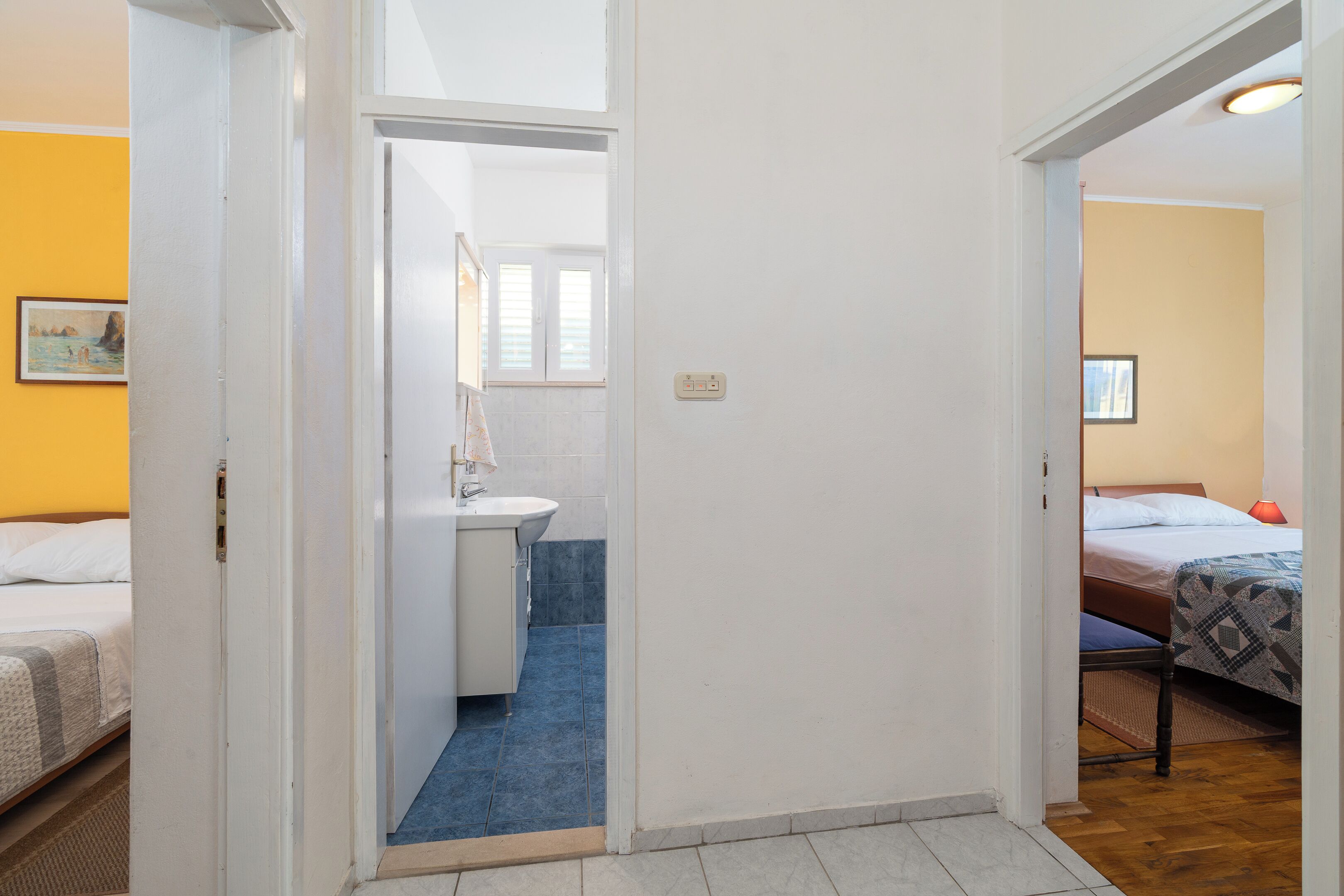 A bedroom with a bed, a bedside table, and a window.
