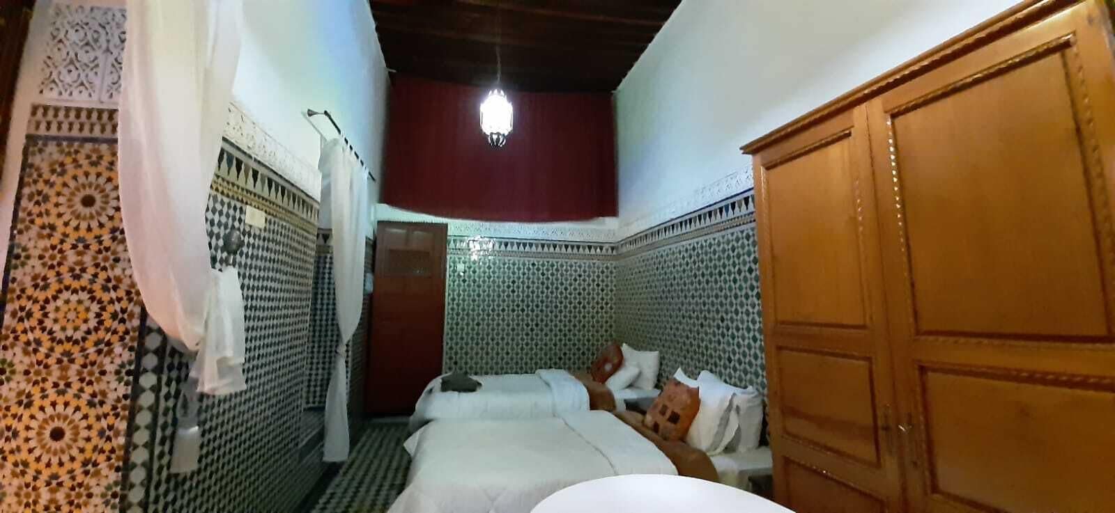 Una habitación con cama, armario de madera y paredes con diseño.