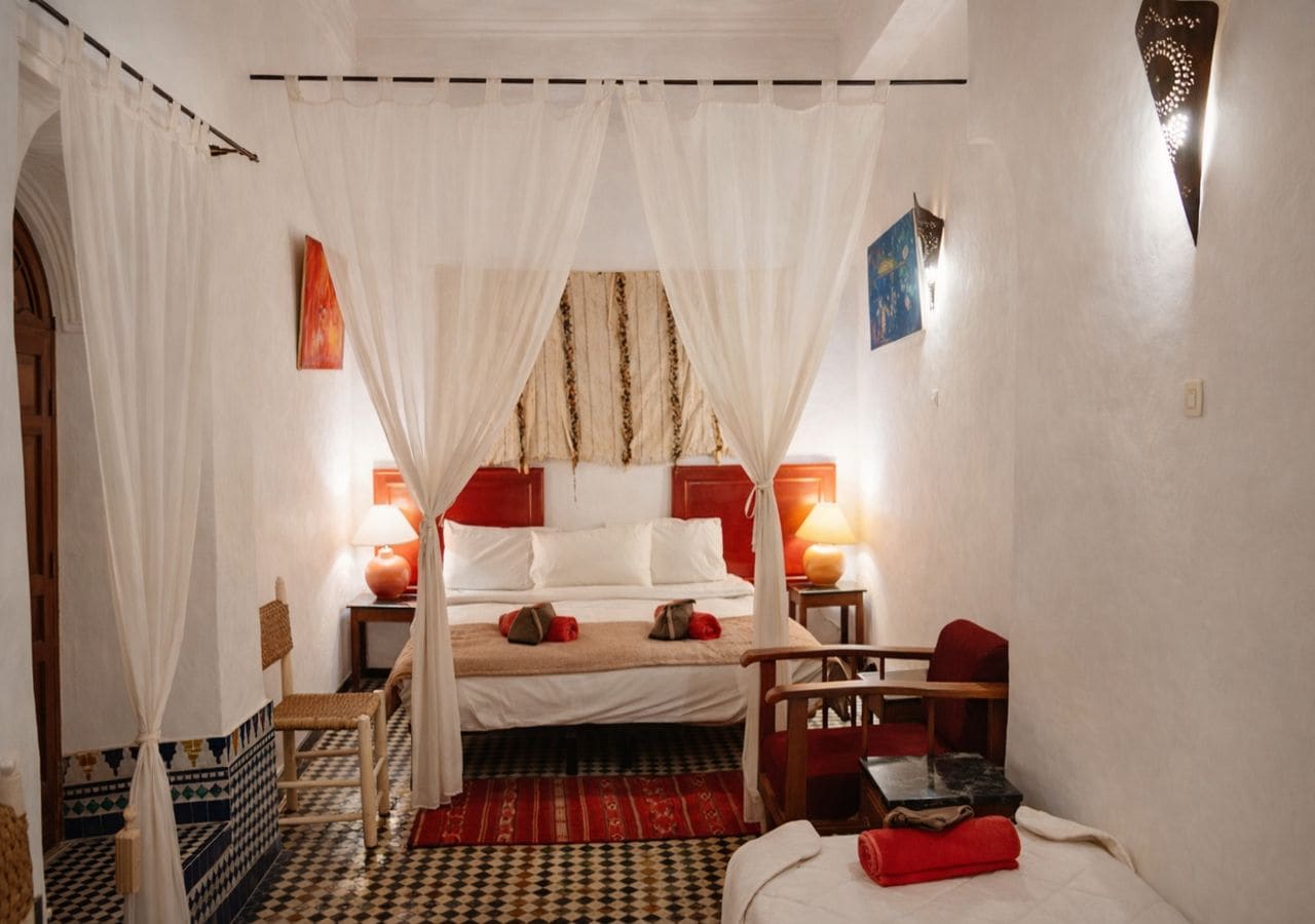 Una habitación con cama, una silla, una mesa y una lámpara.