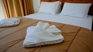 A neatly made bed with a brown bedspread and white pillows. - Kappatos Apartments (Kefalonia)