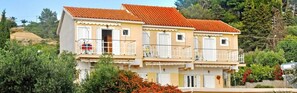 A two-story building with balconies and a red-tiled roof. - Kappatos Apartments (Kefalonia)