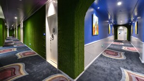 A hallway with green walls, a patterned carpet, and a blue ceiling. - Xiamen Aizhu Lover Hotel - Jimei Branch (Xiamen)