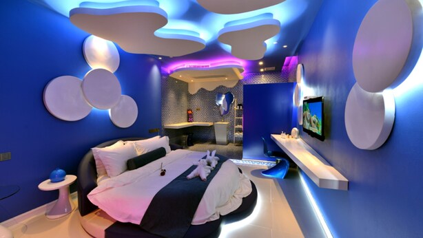 A modern bedroom with a curved bed, a vanity, and a TV on the wall. - Xiamen Aizhu Lover Hotel - Jimei Branch (Xiamen)