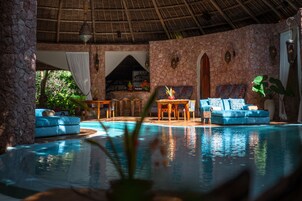 Una piscina al aire libre, sombrillas, sillones reclinables de piscina