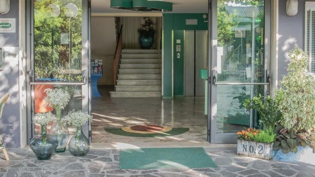 A hotel entrance with a glass door, a green mat, and a staircase leading inside. - Hotel Mirage Bellaria (Bellaria-Igea Marina)