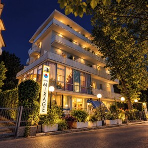 Un hotel de varios pisos con balcones, ventanas amplias y un cartel que indica que es el Hotel Mirage.