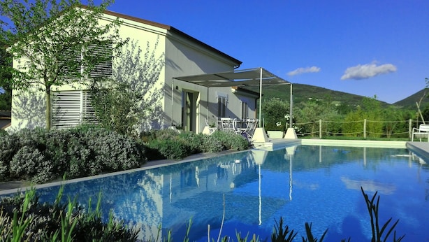 Una piscina con una casa al fondo.