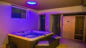 Un baño moderno con una bañera de madera grande, una ventana y una puerta de madera.