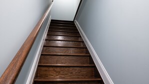 A wooden staircase with a handrail, leading upwards. - 6 Bedroom Duplex Near NYC (Jersey City)
