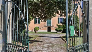 A gated entrance to a building with a paved path leading to a staircase. - Agriturismo Villa Rosselmini (Calci)