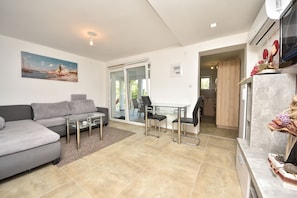 Apartment, Terrasse, Meerblick (A3) | Wohnbereich | Flachbildfernseher