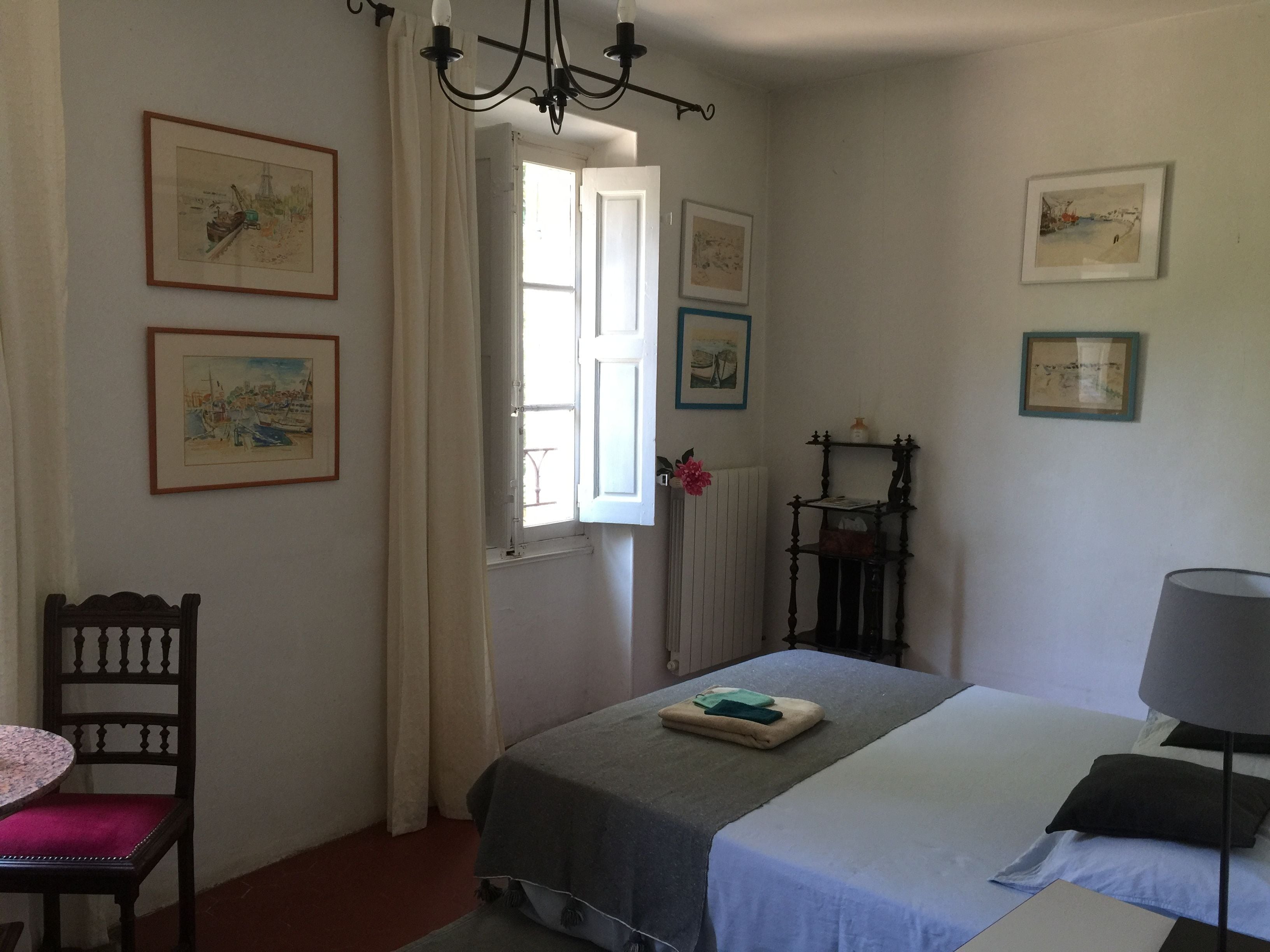 Un dormitorio con dos camas, una silla, una mesa y varias fotografías enmarcadas en las paredes.