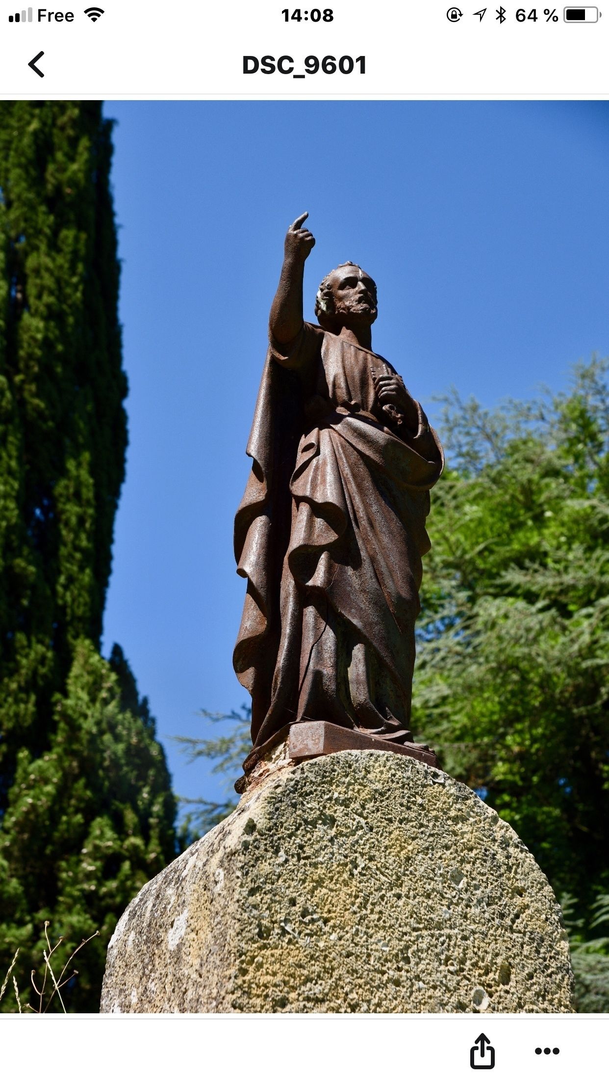 A statue on a rock with a clear sky in the background.