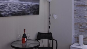 A small room with a round table, a chair, a painting of a stormy sea, a floor lamp, and a nightstand with a lamp. - Royal Apartments (Belgrade)