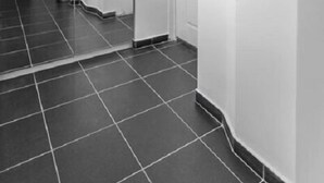 A corridor with a tiled floor leading to a kitchen area. - Royal Apartments (Belgrade)